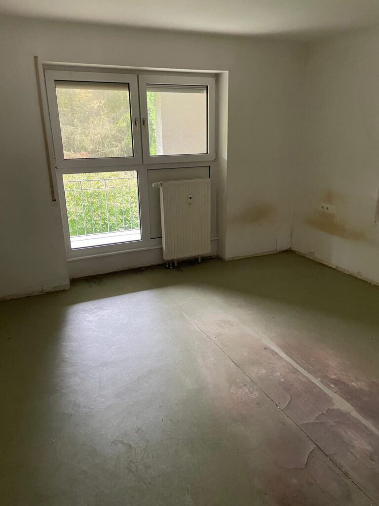 Besenrein geräumtes Zimmer mit Balkonfenster nach der Entrümpelung