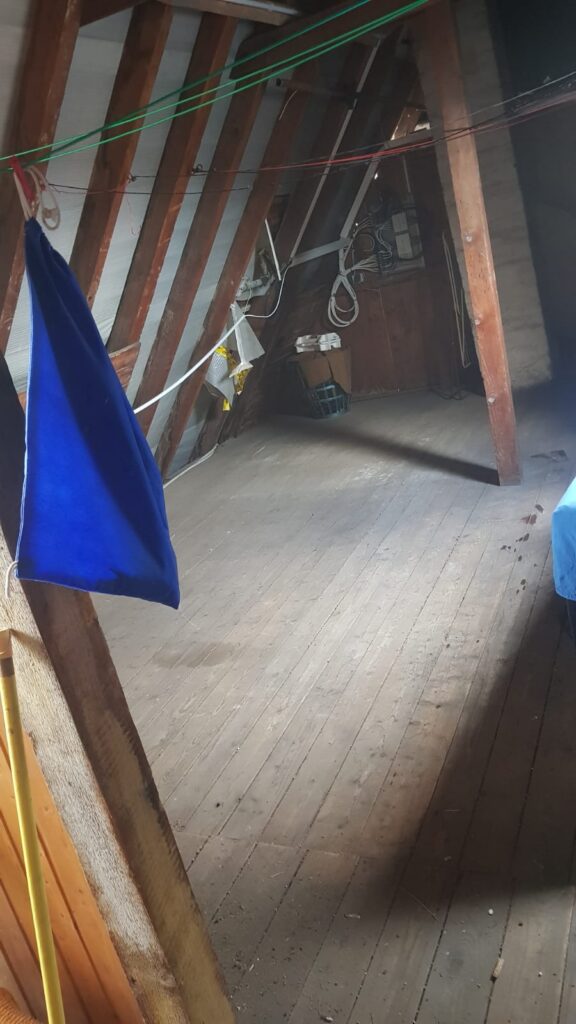 Leerer, besenreiner Dachboden mit Holzdielen nach der Entrümpelung