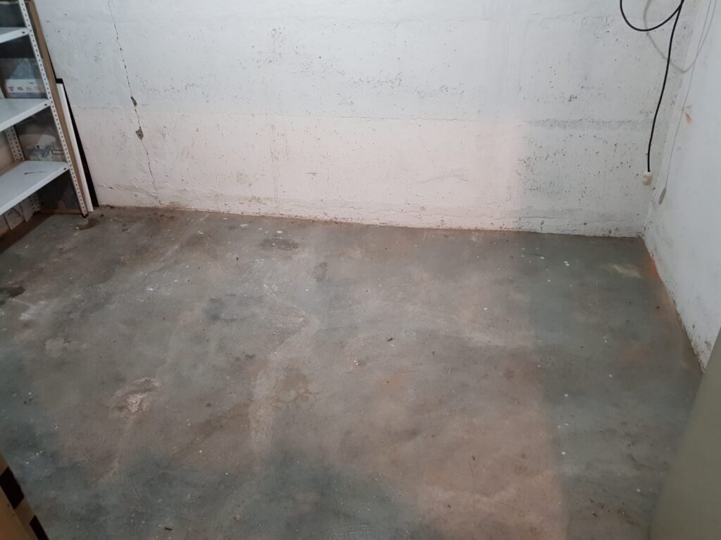 Leerer Kellerraum mit Betonboden nach der Entrümpelung