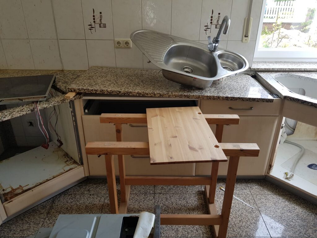 Teilweise abgebaute Einbauküche mit Spüle vor der Haushaltsauflösung