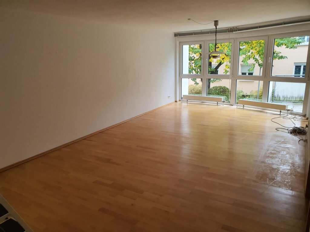 Leeres, besenreines Wohnzimmer mit Parkett nach der Haushaltsauflösung